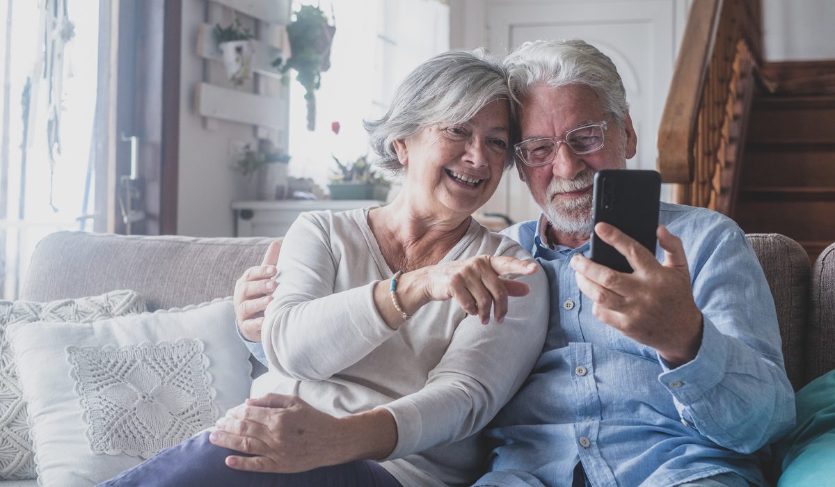 senior couple at home using a cellphone